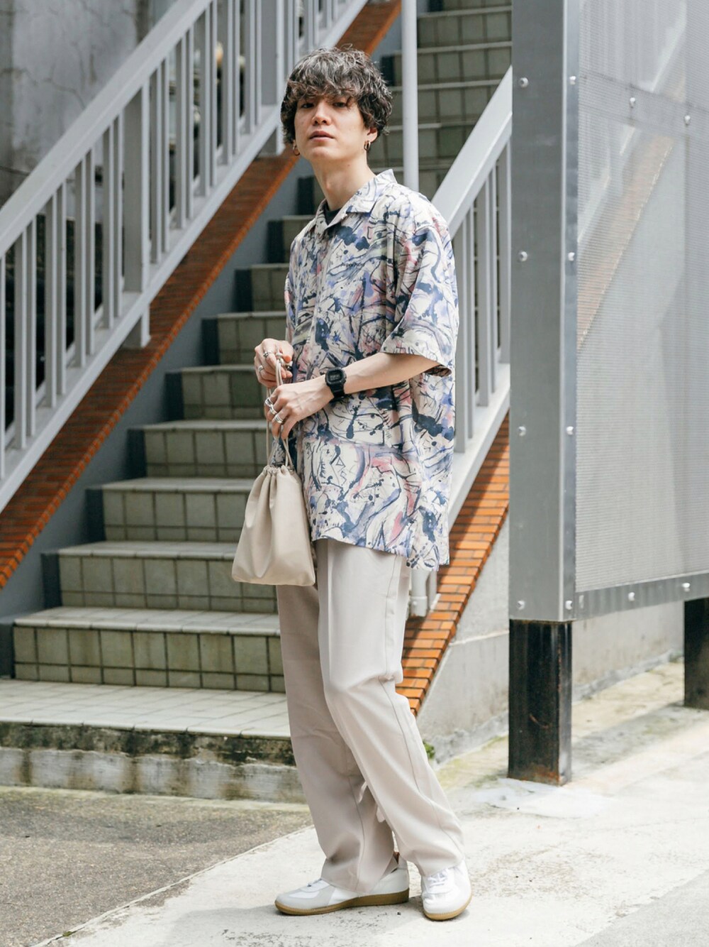 パープル系のシャツ/ブラウス、ベージュ系のバックパック/リュック、ホワイト系のスニーカーを着用したメンズの夏コーディネートの1枚目の写真