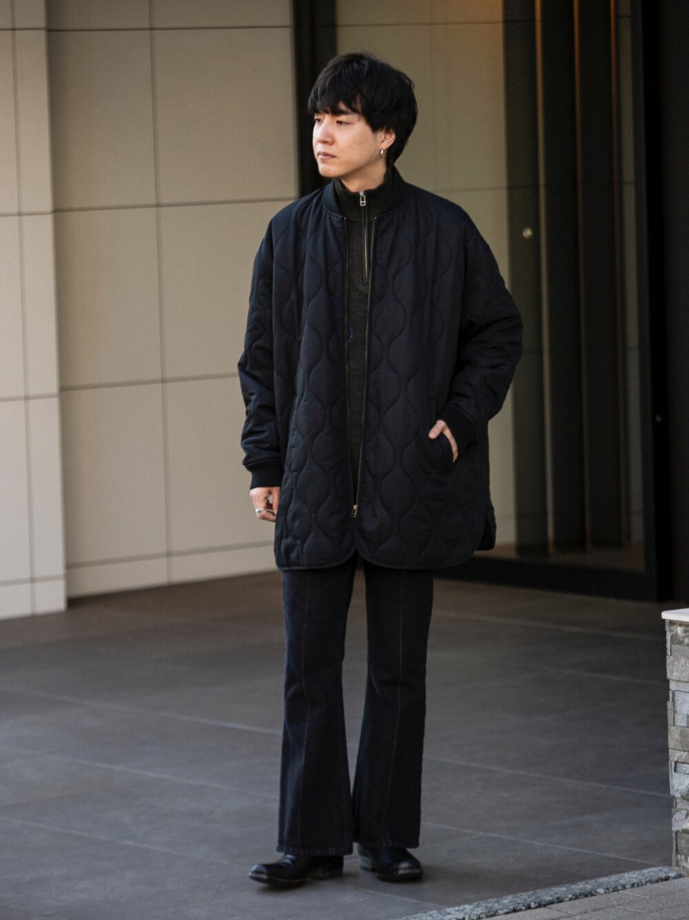 ブラック系のダウンジャケット/コート、グレー系のニット/セーター、ブルー系のデニムパンツを着用したメンズの冬コーディネートの1枚目の写真