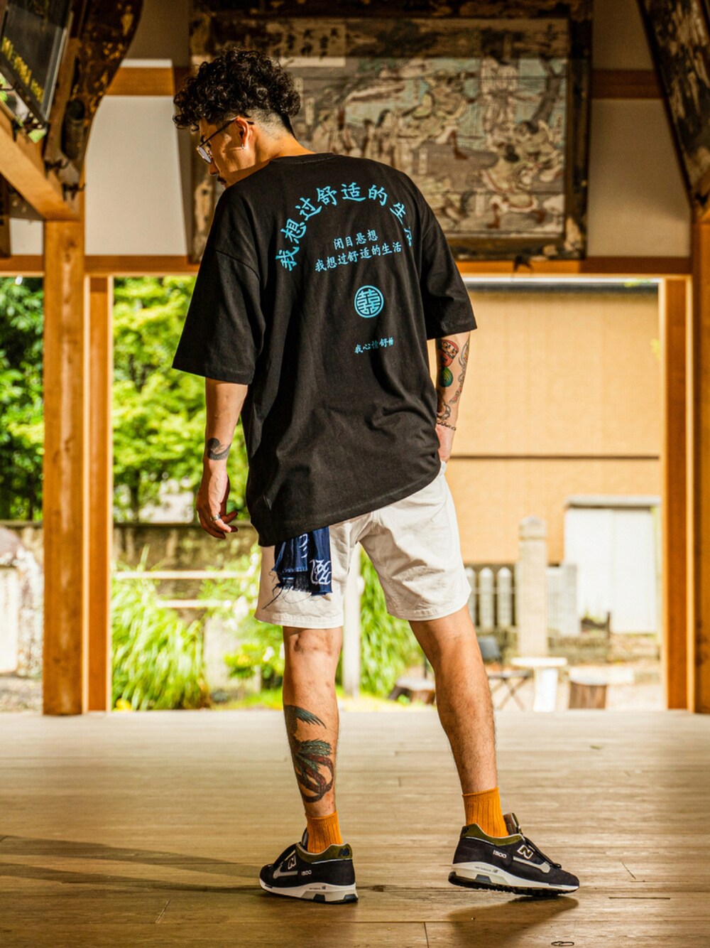 ブラック系のトップス、ホワイト系のその他パンツ、ブルー系のスニーカーを着用したメンズの夏コーディネートの1枚目の写真