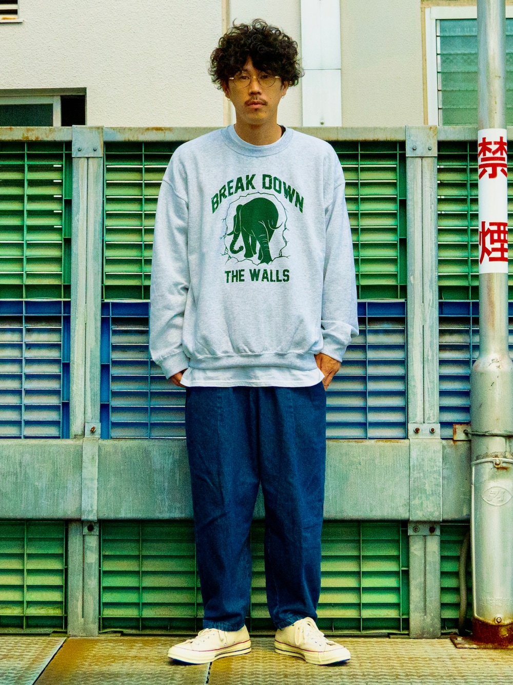 ブラック系のトップス、ブルー系のパンツ、ホワイト系のシューズを着用したメンズの秋コーディネートの1枚目の写真
