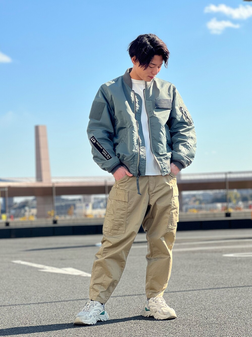 ホワイト系のTシャツ/カットソー、グリーン系のミリタリージャケット、ベージュ系のカーゴパンツを着用したメンズの冬コーディネートの1枚目の写真