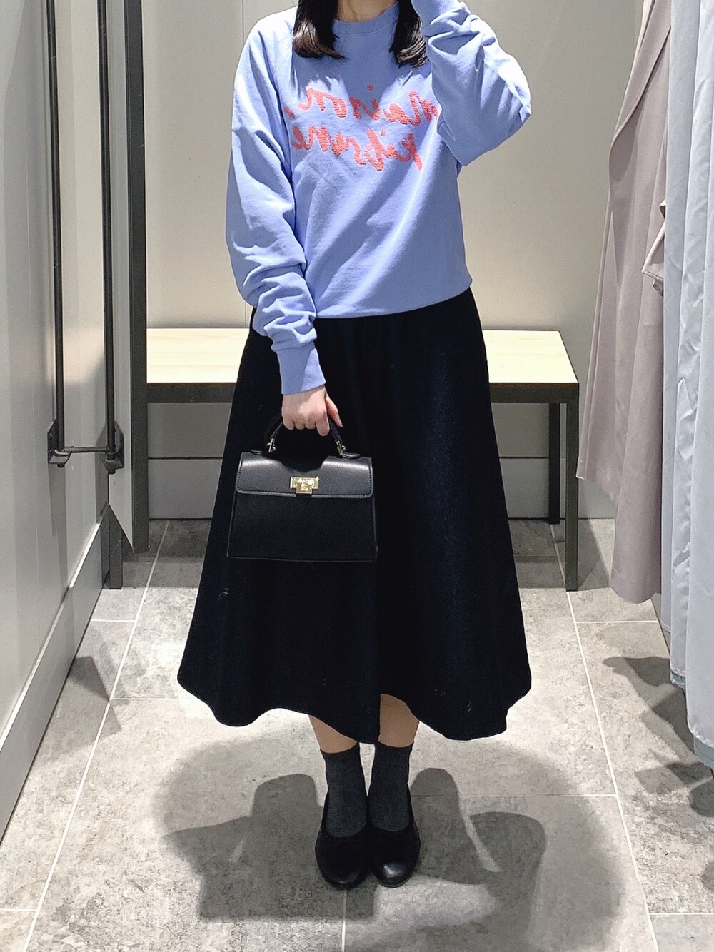 ブルー系のスウェット、ブルー系のスカート、ブラック系のショルダーバッグを着用したレディースの春コーディネートの1枚目の写真