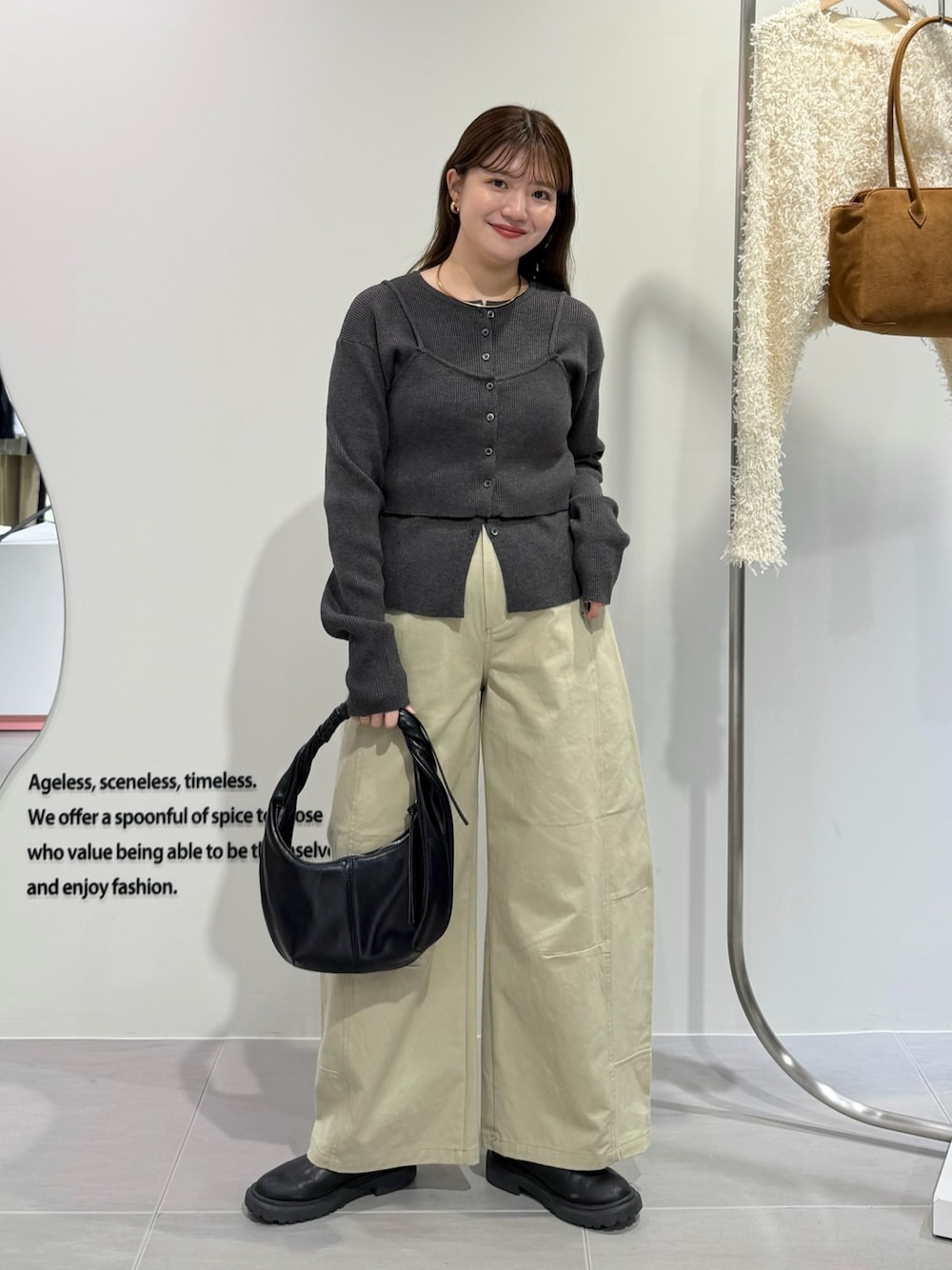 グレー系のニット/セーター、ベージュ系のその他パンツ、ブラック系のハンドバッグを着用したレディースの秋コーディネートの1枚目の写真