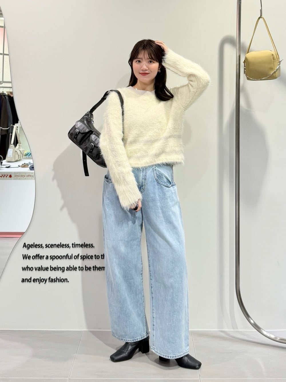 ホワイト系のニット/セーター、ブルー系のデニムパンツ、ブラウン系のショルダーバッグを着用したレディースの冬コーディネートの1枚目の写真