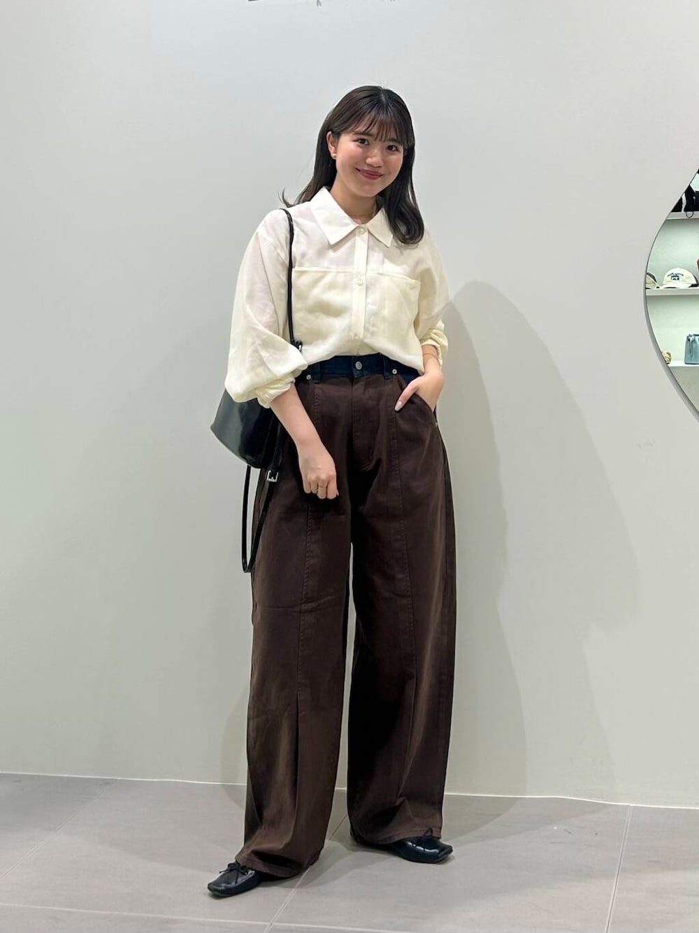 ブラック系のショルダーバッグ、ホワイト系のシャツ/ブラウス、ブラウン系のその他パンツを着用したレディースの春コーディネートの1枚目の写真