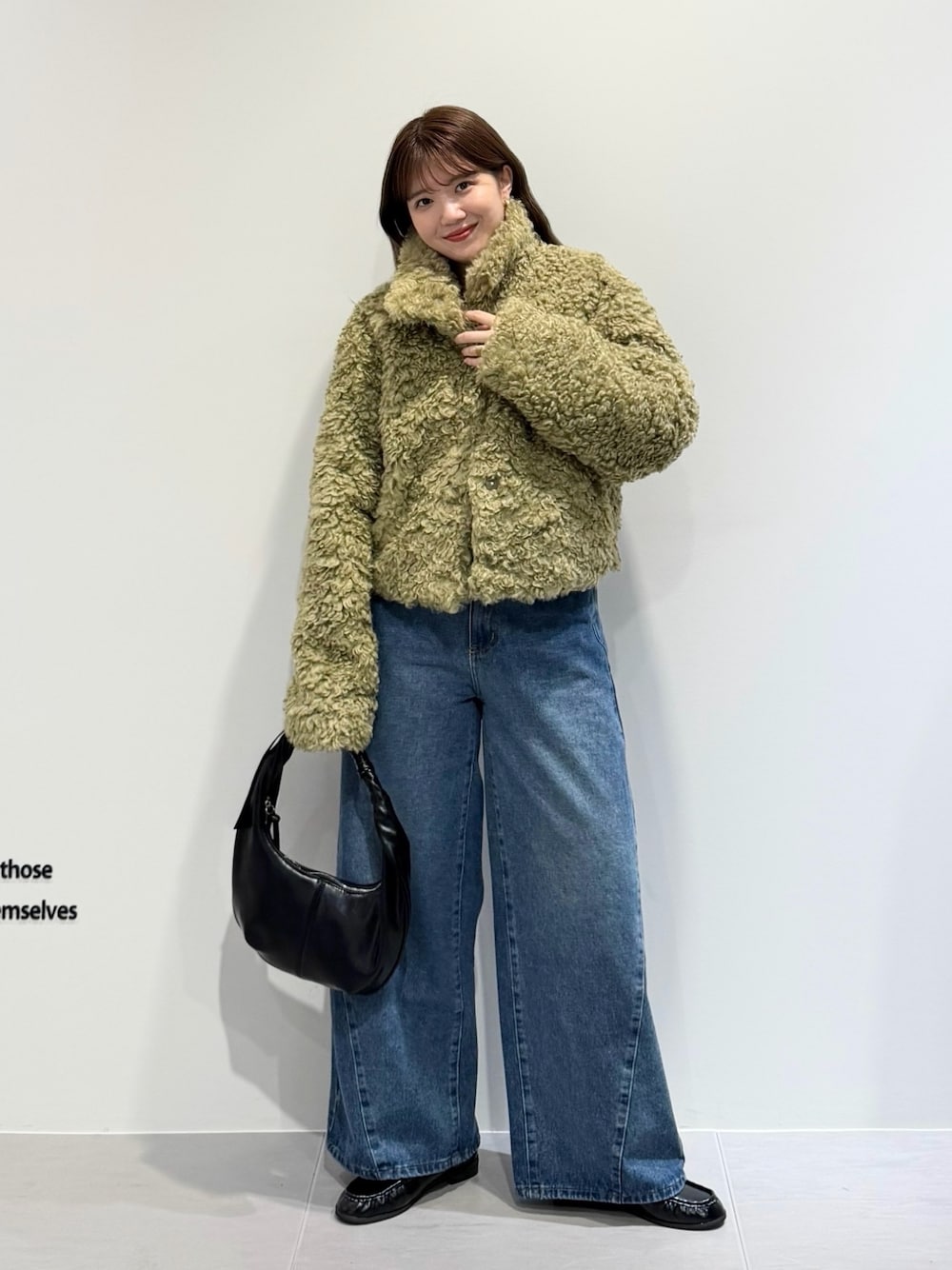 グリーン系のその他アウター、ブルー系のデニムパンツ、ブラック系のハンドバッグを着用したレディースの秋コーディネートの1枚目の写真