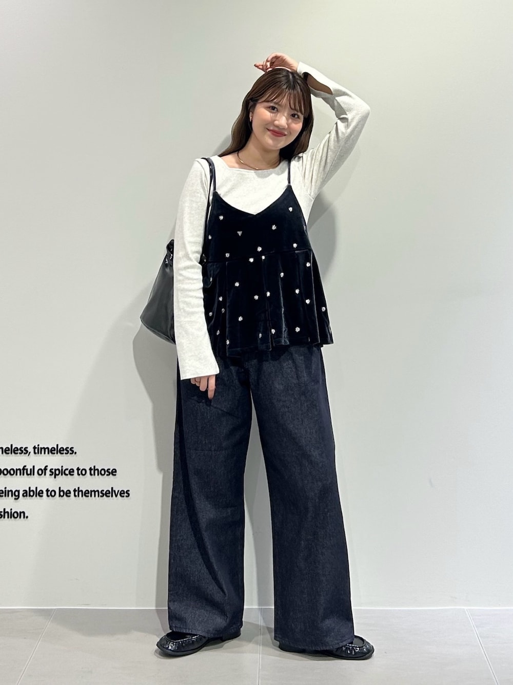 グレー系のキャミソール、グレー系のTシャツ/カットソー、ブルー系のデニムパンツを着用したレディースの秋コーディネートの1枚目の写真