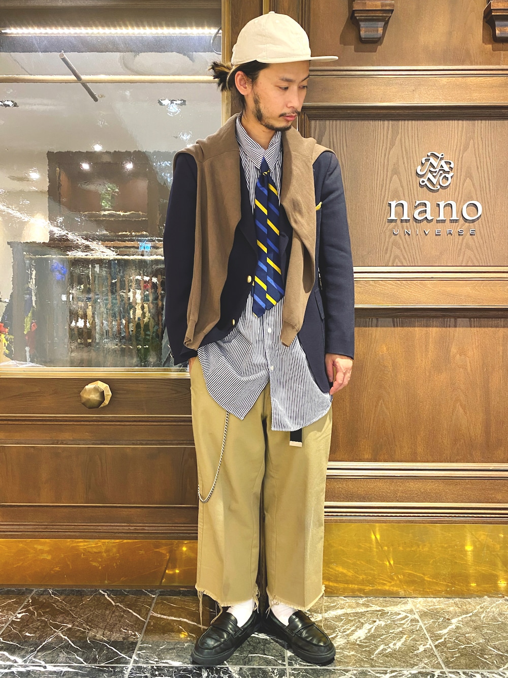 「ブレザー、紺ブレ、ストライプシャツ、ビッグシャツ、カーディガン、タイドアップ、ネクタイ、ワイドパンツ、カットオフ、チノパン、ガチャベルト、ウォレットチェーン、スリッポン、ローファー、ベースボールキャップ」｜「NANO universeのマーセライズドミラノリブVネックカーディガン（カーディガン/ボレロ、ベージュ系）」を使った、窪田 孝之さん（メンズ・170cm）の秋コーディネートの1枚目の写真
