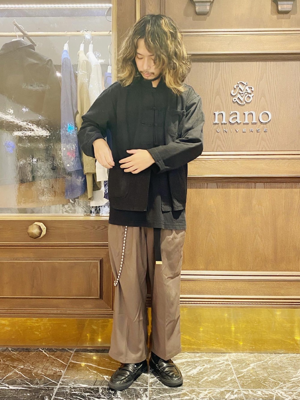 ブラウン系のスラックスを着用したメンズの春コーディネートの1枚目の写真