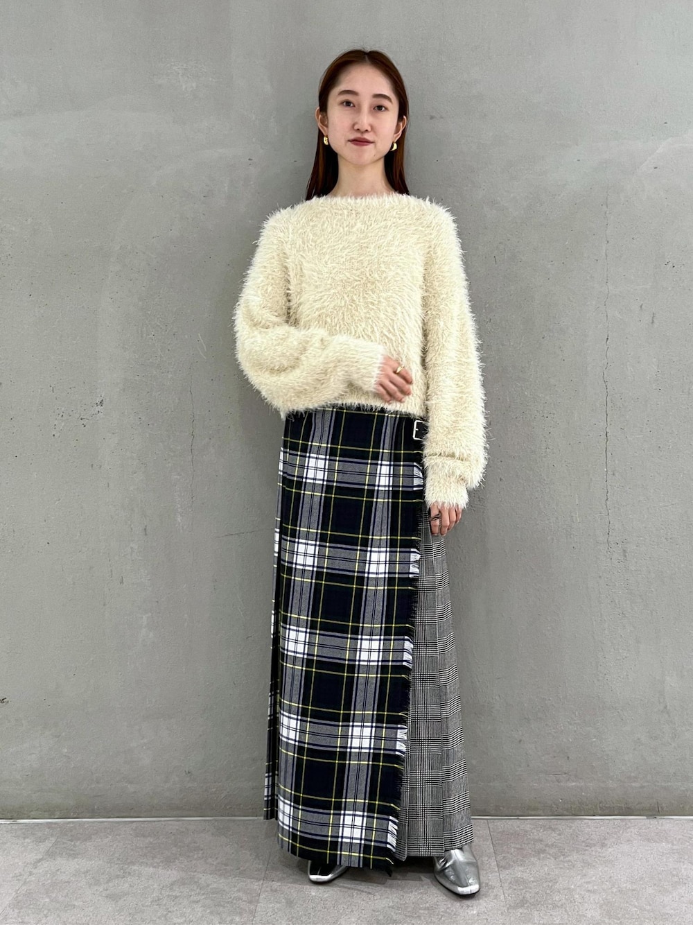 シルバー系のブーツ、ホワイト系のニット/セーター、グリーン系のスカートを着用したレディースの秋コーディネートの1枚目の写真