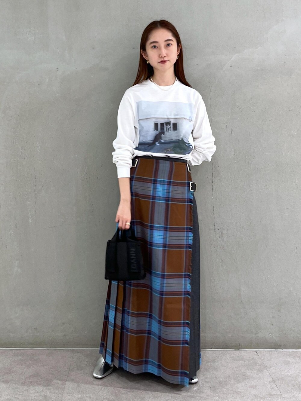 シルバー系のブーツ、ホワイト系のTシャツ/カットソー、ブラウン系のスカートを着用したレディースの秋コーディネートの1枚目の写真