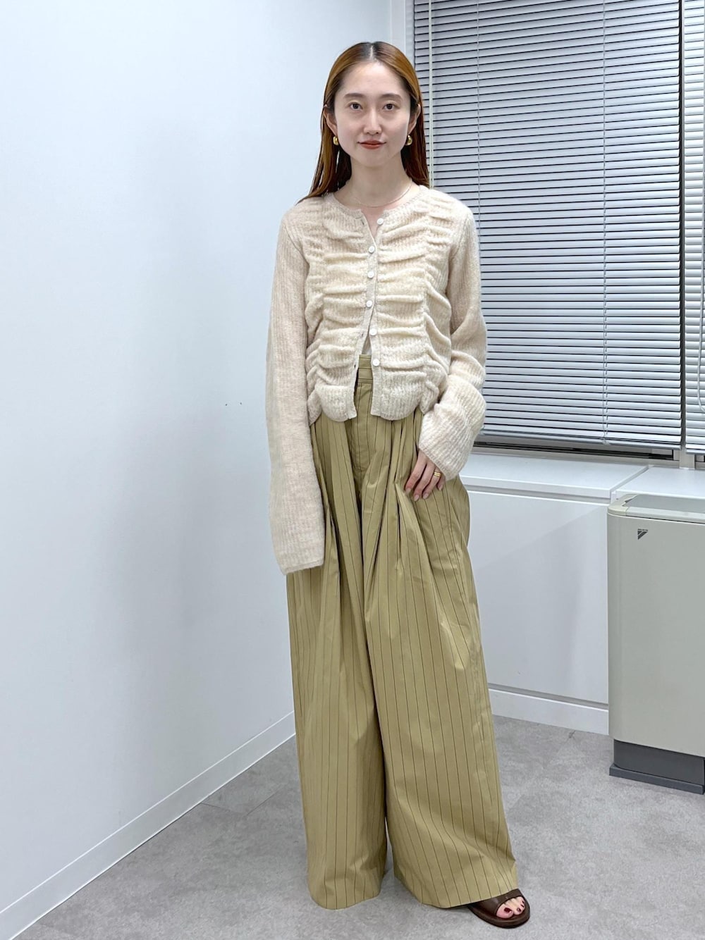 ブラウン系のサンダル、ベージュ系のスラックス、ベージュ系のカーディガン/ボレロを着用したレディースの夏コーディネートの1枚目の写真