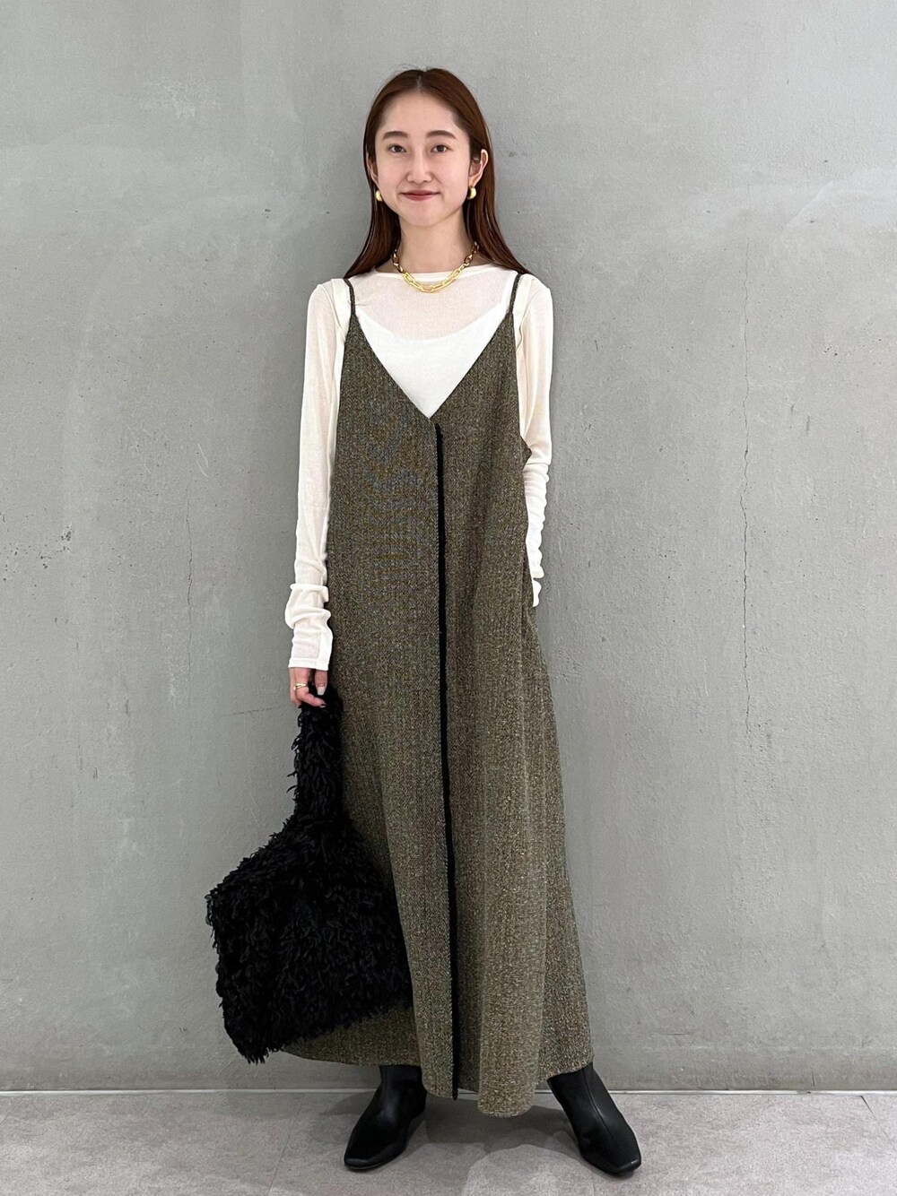 ブラック系のブーツ、ベージュ系のワンピース、ホワイト系のTシャツ/カットソーを着用したレディースの秋コーディネートの1枚目の写真