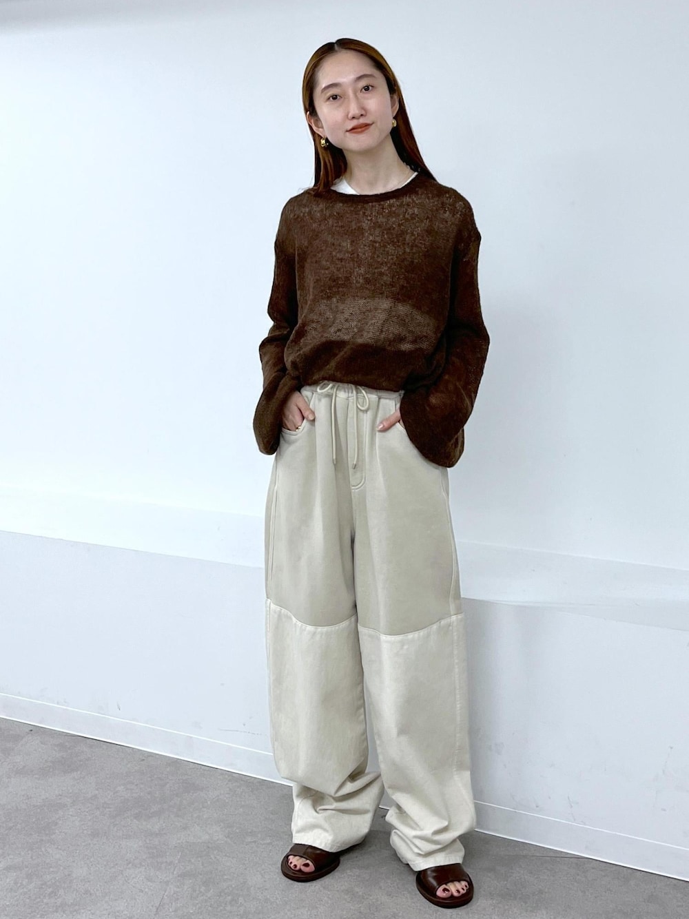 ブラウン系のサンダル、ブラウン系のニット/セーター、ベージュ系のその他パンツを着用したレディースの夏コーディネートの1枚目の写真