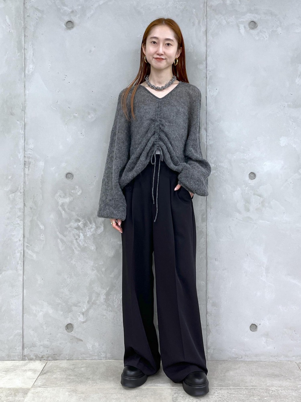 ブラック系のサンダル、グレー系のニット/セーター、ブラック系のスラックスを着用したレディースの夏コーディネートの1枚目の写真