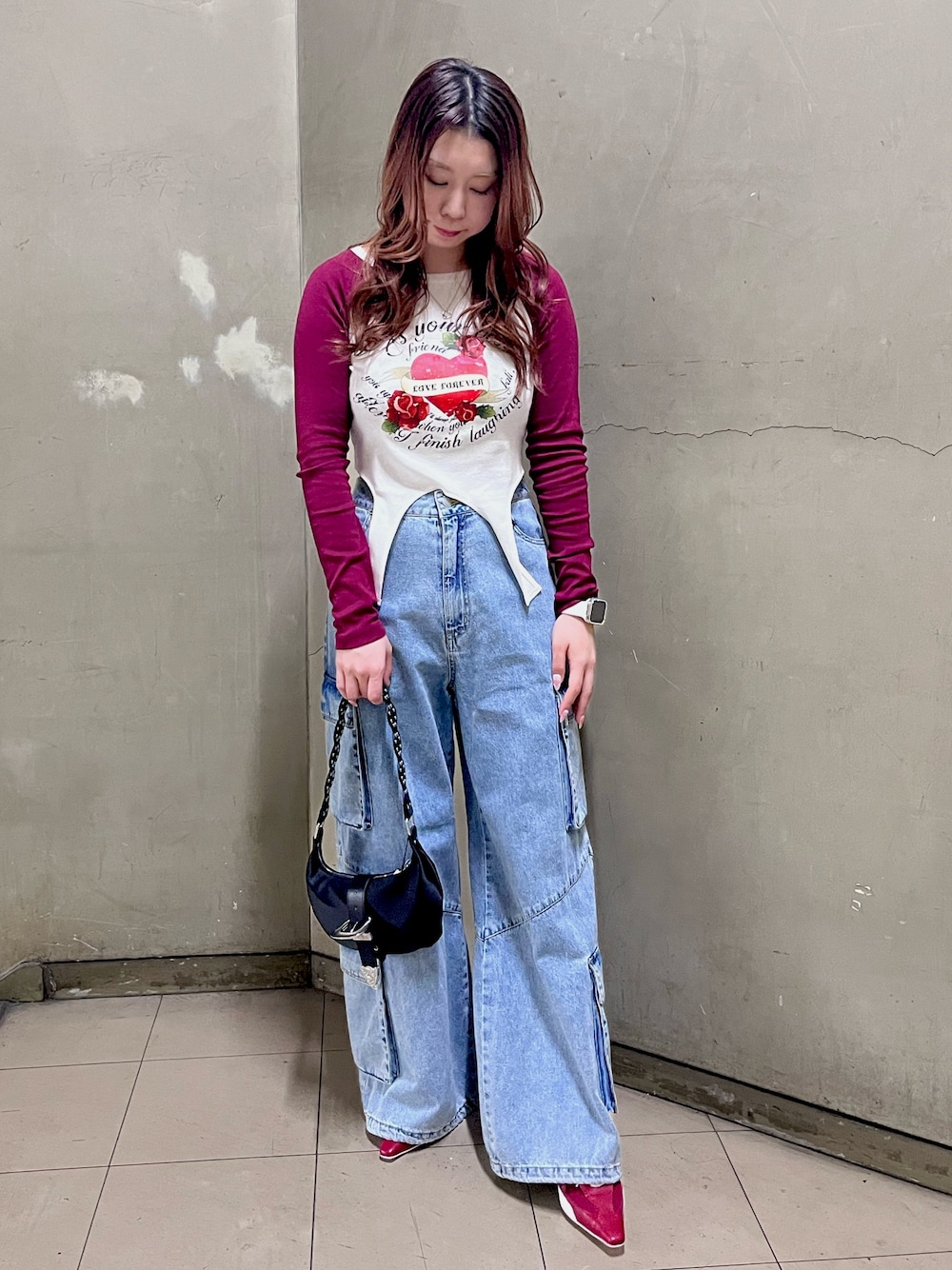 レッド系のTシャツ/カットソー、ブルー系のデニムパンツ、ブラック系のショルダーバッグを着用したレディースの春コーディネートの1枚目の写真
