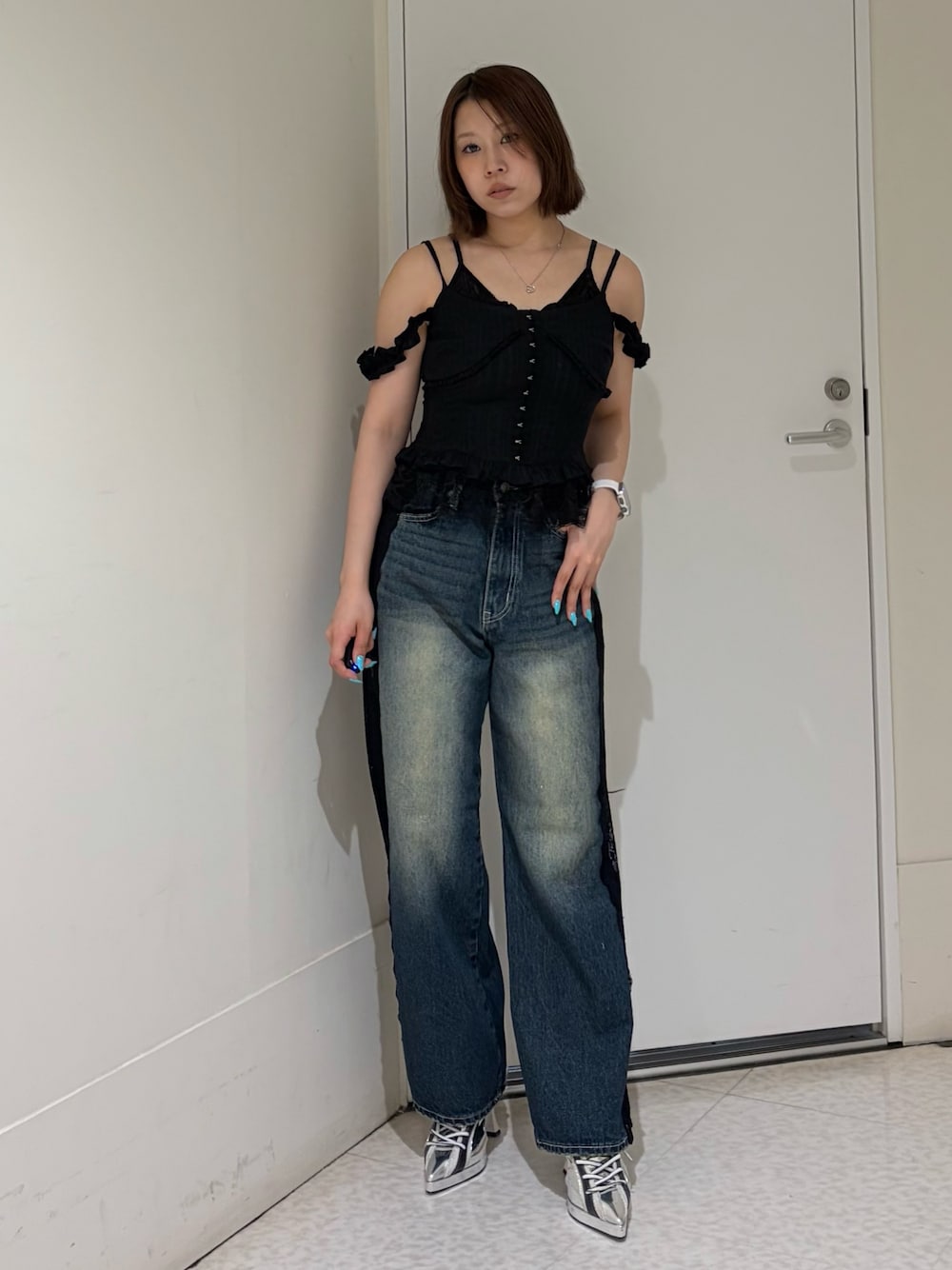 ブラック系のキャミソール、ブルー系のデニムパンツ、ブラック系のサンダルを着用したレディースの春コーディネートの1枚目の写真