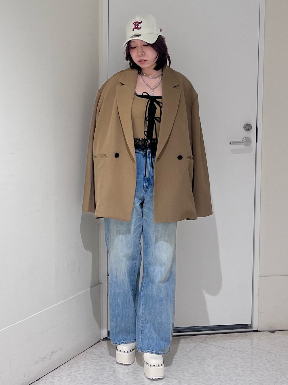 ブラウン系のテーラードジャケット、ブラウン系のシャツ/ブラウス、ブルー系のデニムパンツを着用したレディースの春コーディネートの1枚目の写真