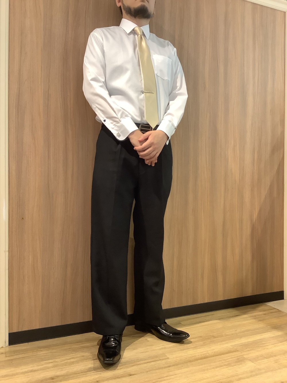 イエロー系のネクタイ、ホワイト系のビジネスシャツ、シルバー系のネクタイピンを着用したメンズの春コーディネートの1枚目の写真