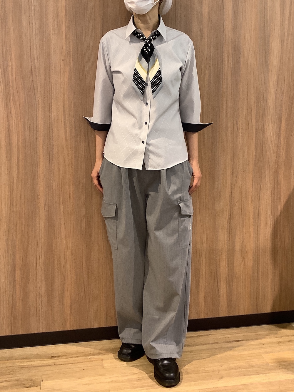 グレー系のビジネスシャツ、ブラック系のバンダナ/スカーフを着用したレディースの春コーディネートの1枚目の写真
