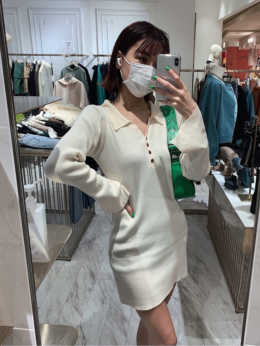 ホワイト系のワンピース、グリーン系のショルダーバッグ、ブラック系のブーツを着用したレディースの冬コーディネートの1枚目の写真