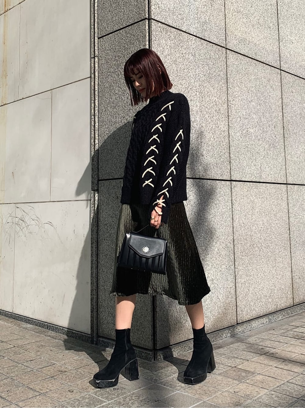 ブラック系のニット/セーター、ブラック系のショルダーバッグ、ベージュ系のワンピースを着用したレディースの冬コーディネートの1枚目の写真