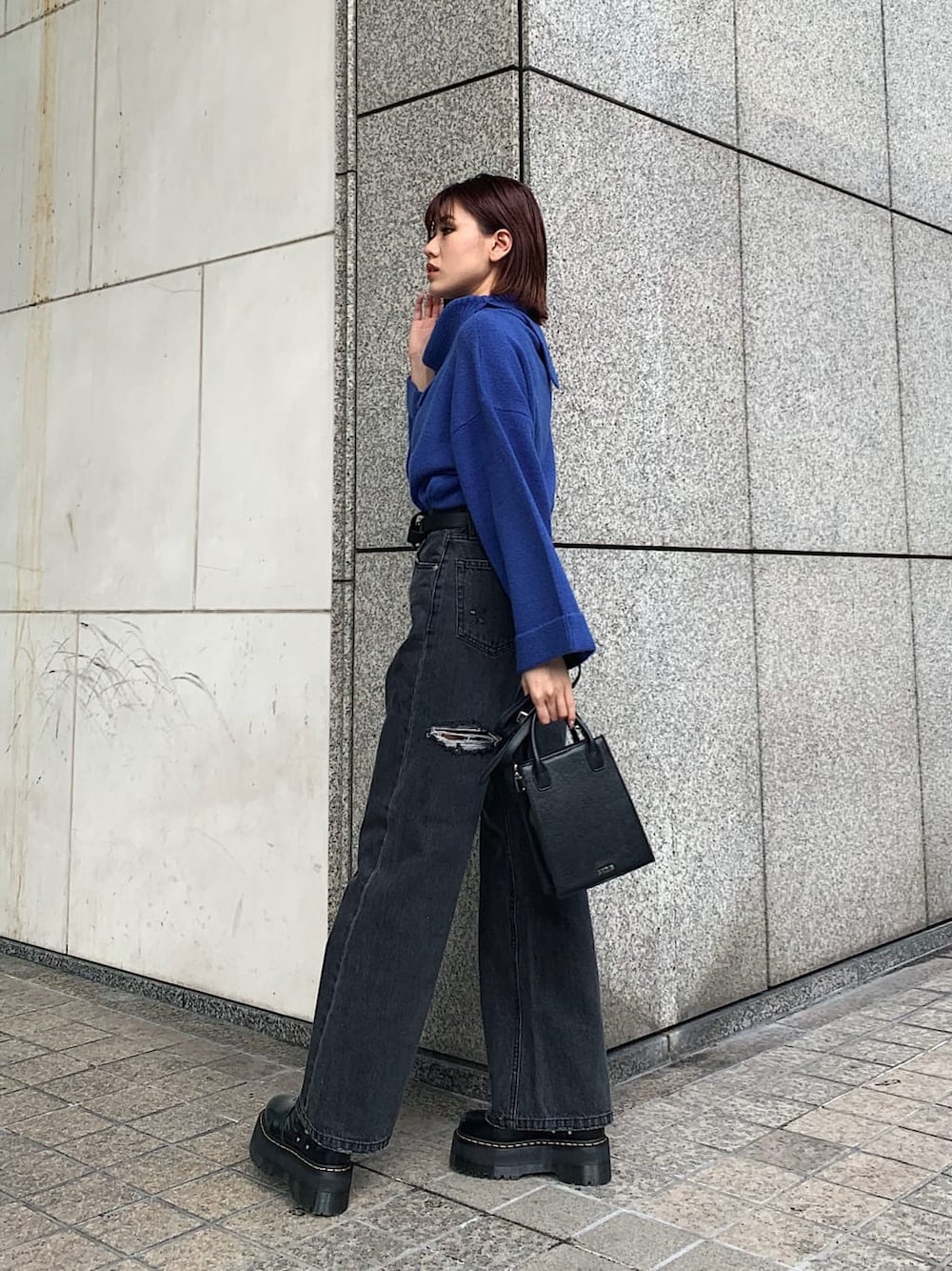 ブラック系のデニムパンツ、ブラック系のブーツ、ブラック系のショルダーバッグを着用したレディースの冬コーディネートの1枚目の写真