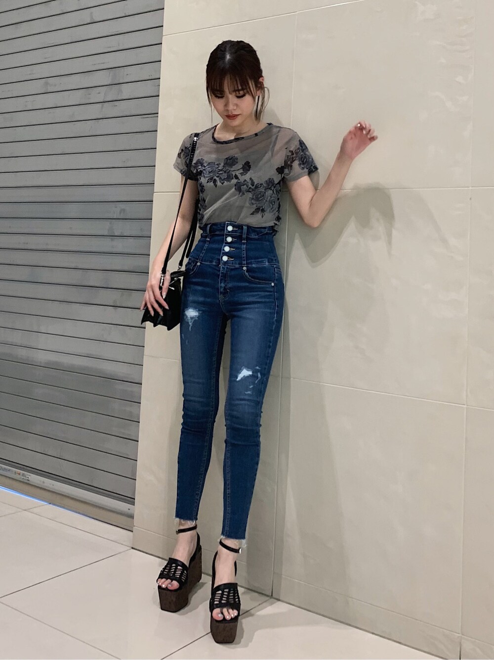 ブルー系のデニムパンツ、ブラック系のサンダルを着用したレディースの春コーディネートの1枚目の写真