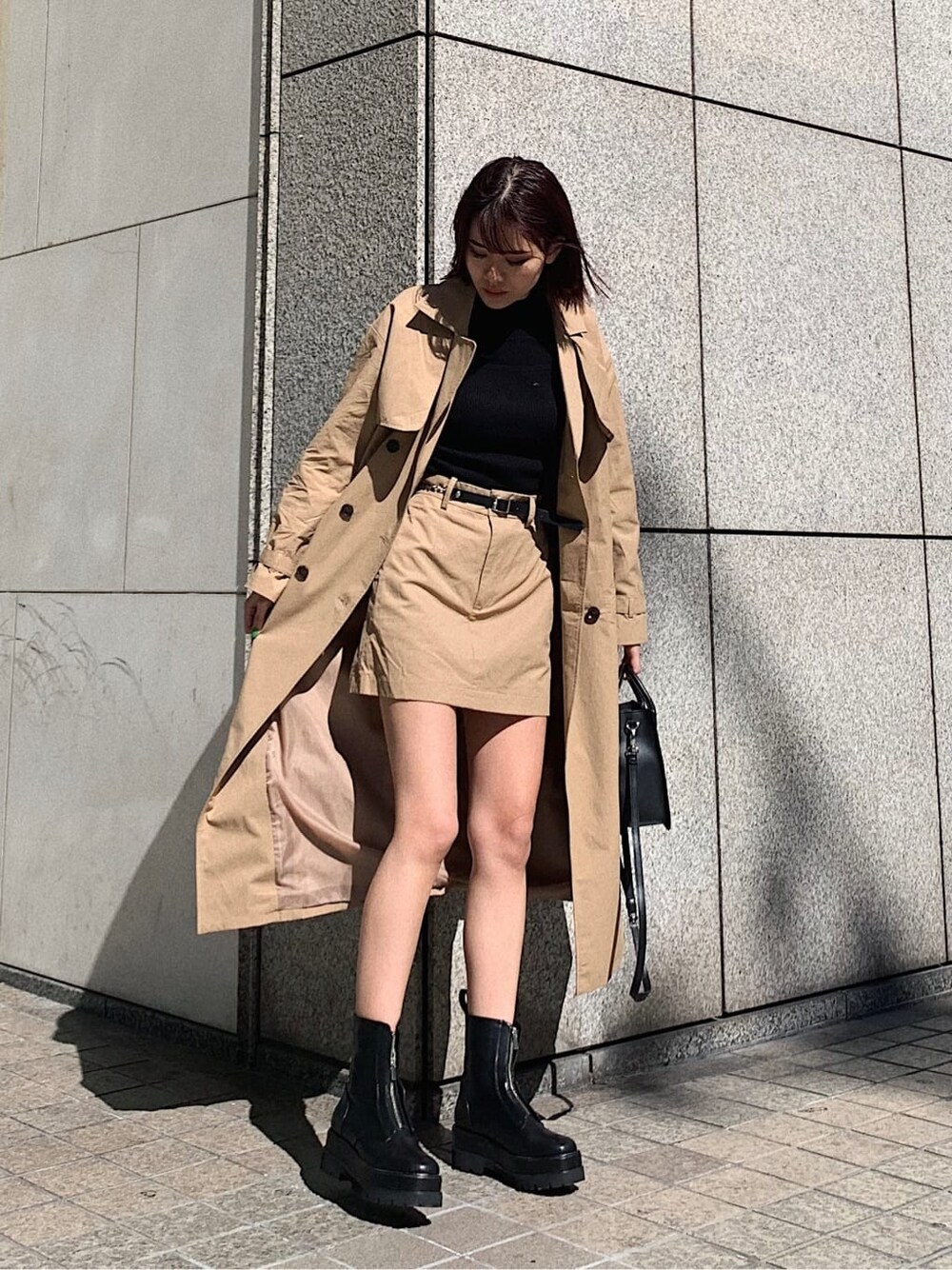 ベージュ系のスカート、ブラック系のブーツ、ブラック系のニット/セーターを着用したレディースの冬コーディネートの1枚目の写真