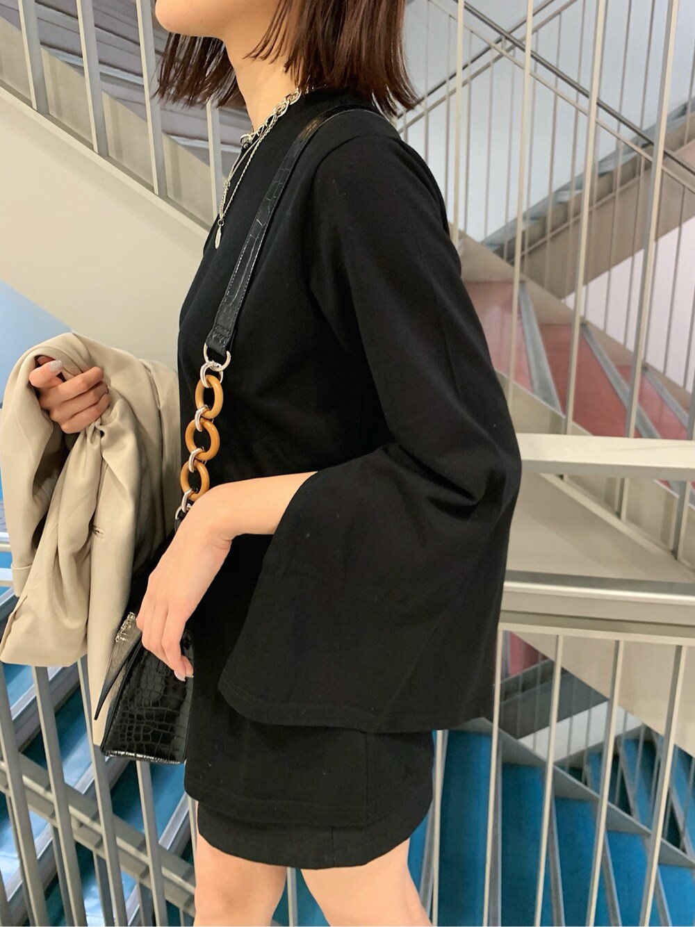 グレー系のテーラードジャケット、ブラック系のTシャツ/カットソー、ブラック系のスカートを着用したレディースの冬コーディネートの1枚目の写真