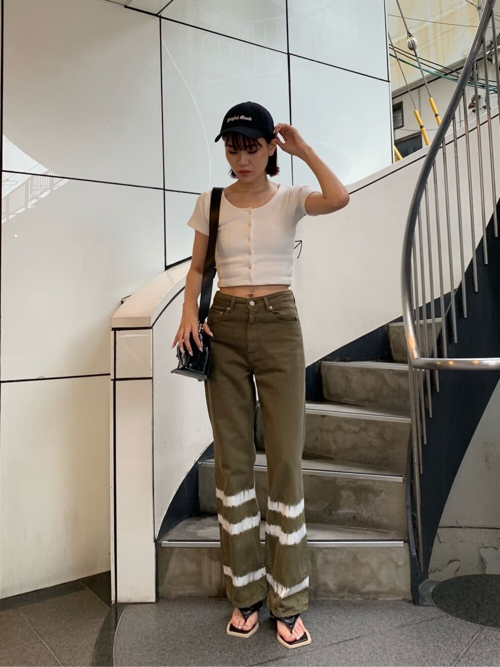 ホワイト系のTシャツ/カットソー、ブラック系のサンダル、ブラック系のショルダーバッグを着用したレディースの夏コーディネートの1枚目の写真