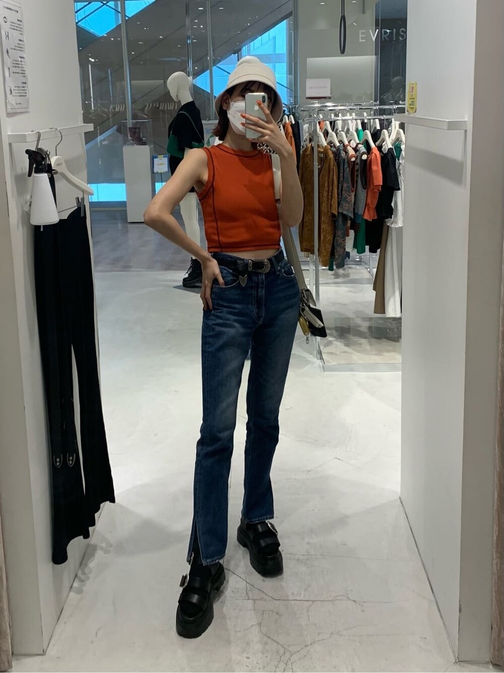 ホワイト系のショルダーバッグ、オレンジ系のTシャツ/カットソー、ブラック系のサンダルを着用したレディースの夏コーディネートの1枚目の写真