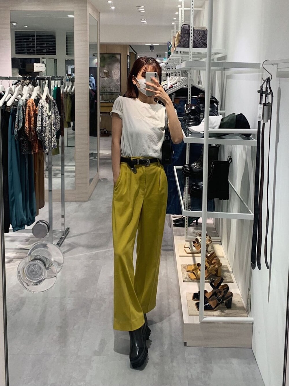 イエロー系のスラックス、ホワイト系のTシャツ/カットソー、ブラック系のブーツを着用したレディースの春コーディネートの1枚目の写真