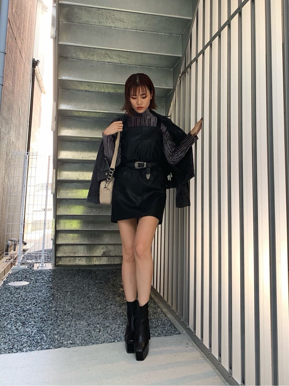 グレー系のTシャツ/カットソー、ブラック系のブーツ、ホワイト系のショルダーバッグを着用したレディースの秋コーディネートの1枚目の写真