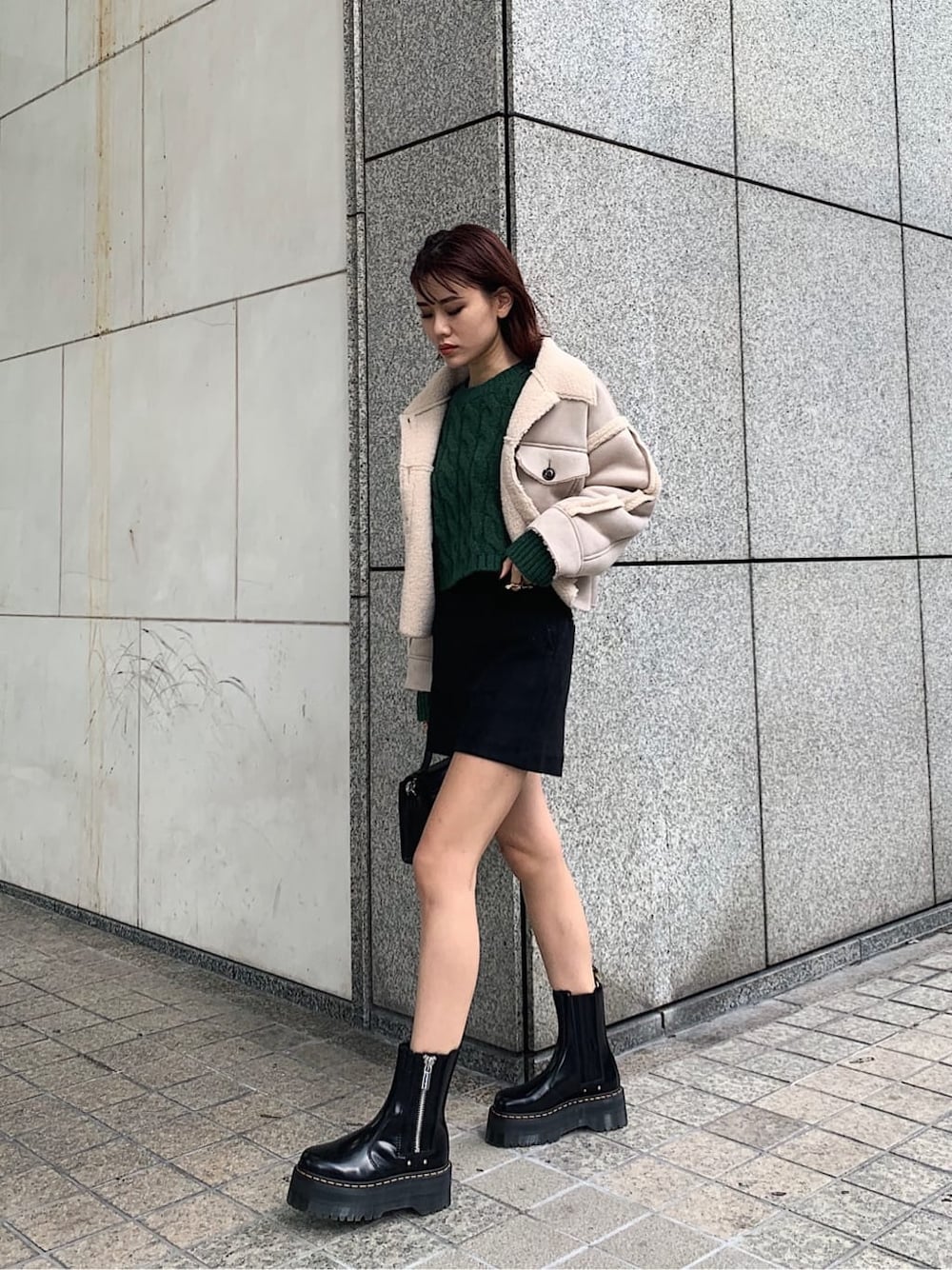 ブラック系のブーツ、ブラック系のその他パンツ、グリーン系のニット/セーターを着用したレディースの秋コーディネートの1枚目の写真