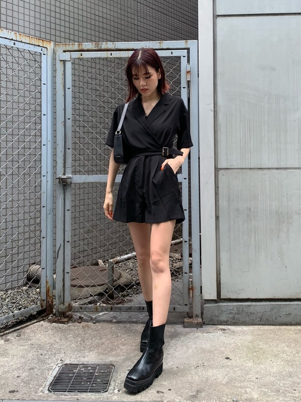 ブラック系のブーツ、ブラック系のつなぎ/オールインワン、ブラック系のショルダーバッグを着用したレディースの春コーディネートの1枚目の写真