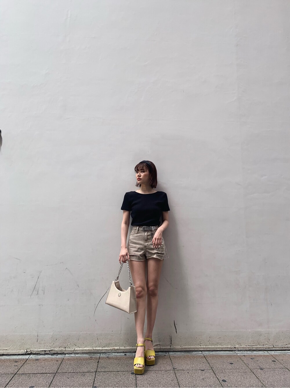 イエロー系のサンダル、ベージュ系のデニムパンツ、ブラック系のTシャツ/カットソーを着用したレディースの春コーディネートの1枚目の写真