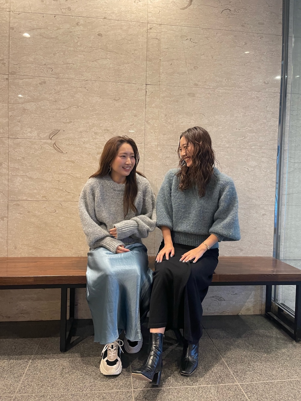 グリーン系のニット/セーター、ブラック系のブーツ、ブラック系のスカートを着用したレディースの冬コーディネートの1枚目の写真