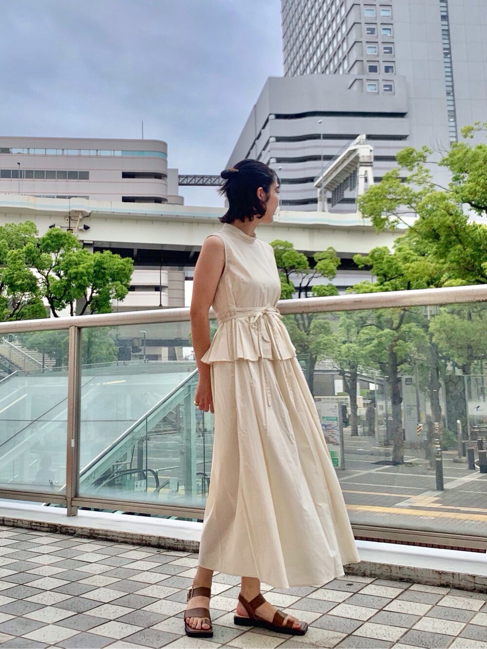 ブラウン系のサンダル、ホワイト系のワンピースを着用したレディースの夏コーディネートの1枚目の写真