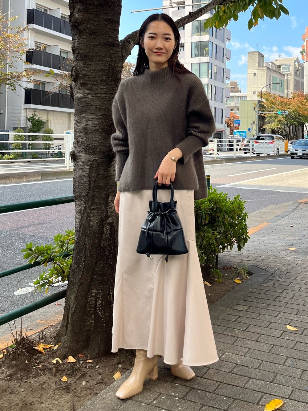 ベージュ系のニット/セーター、ベージュ系のブーツ、グレー系のスカートを着用したレディースの冬コーディネートの1枚目の写真