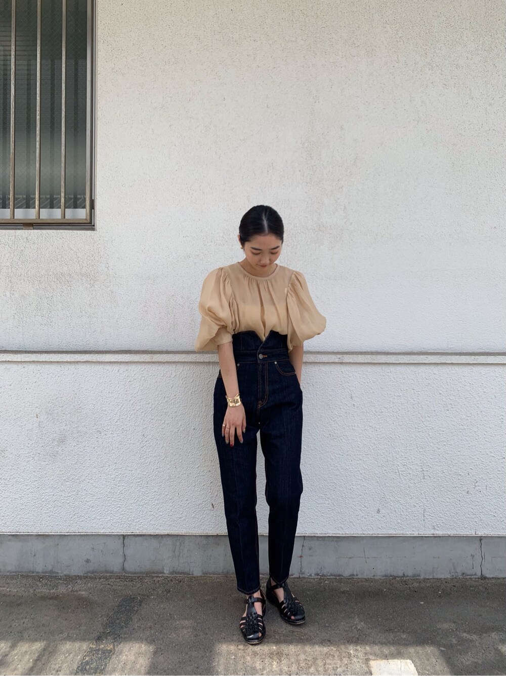 ベージュ系のシャツ/ブラウス、ブルー系のデニムパンツ、ゴールド系のバングル/リストバンドを着用したレディースの春コーディネートの1枚目の写真