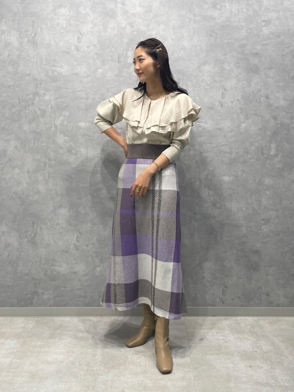 ベージュ系のブーツ、ホワイト系のニット/セーター、パープル系のスカートを着用したレディースの秋コーディネートの1枚目の写真