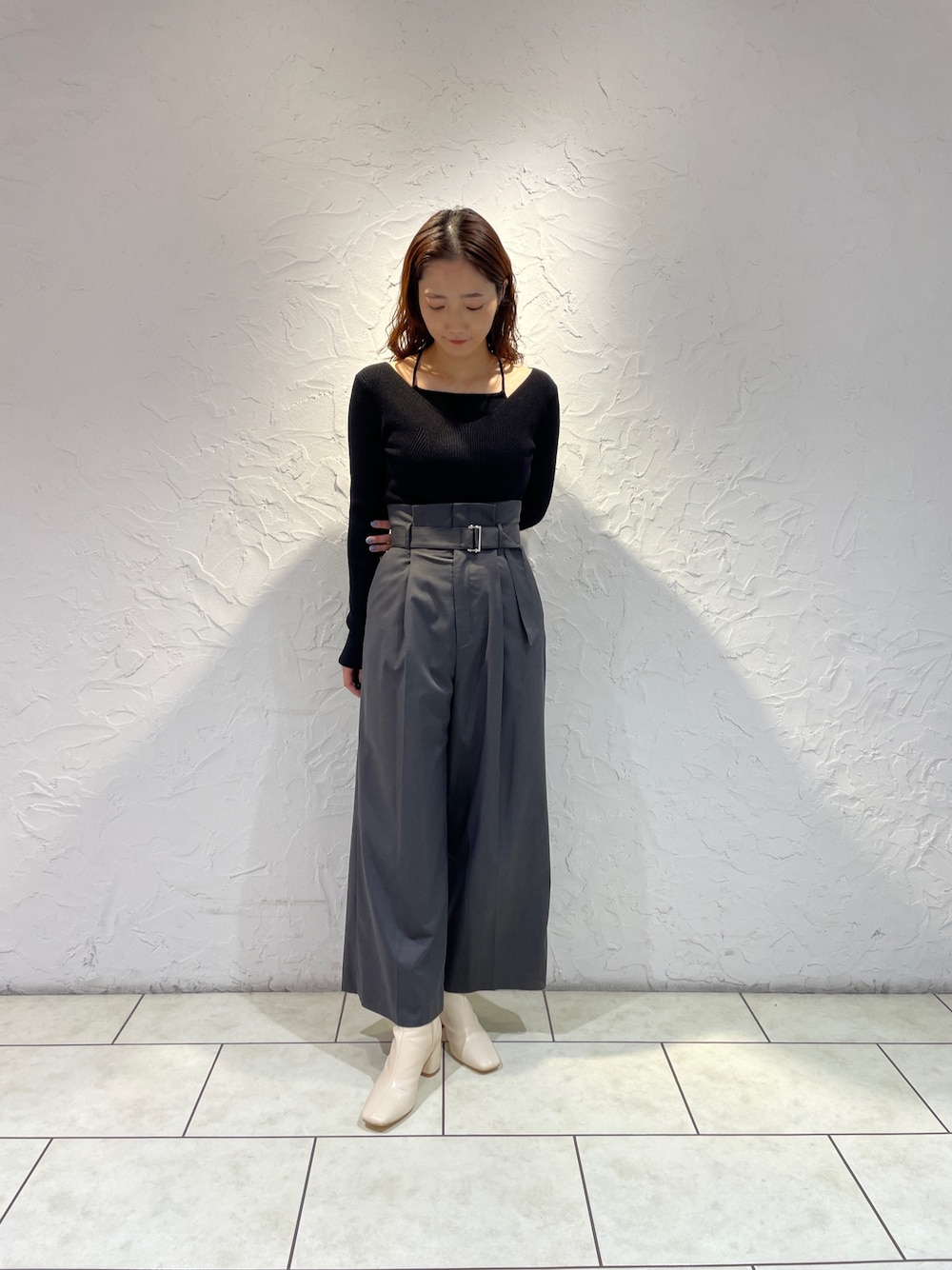 グレー系のその他パンツ、ブラック系のニット/セーター、ホワイト系のブーツを着用したレディースの冬コーディネートの1枚目の写真