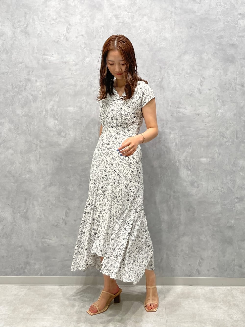 ベージュ系のサンダル、ホワイト系のワンピースを着用したレディースの夏コーディネートの1枚目の写真