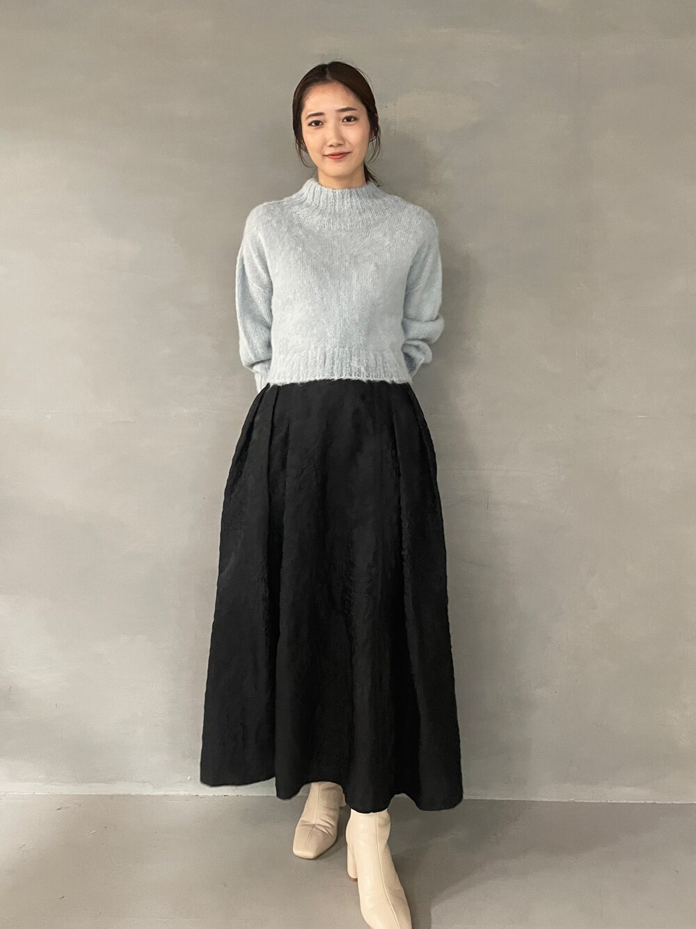 ホワイト系のブーツ、ブラック系のスカート、グリーン系のニット/セーターを着用したレディースの夏コーディネートの1枚目の写真