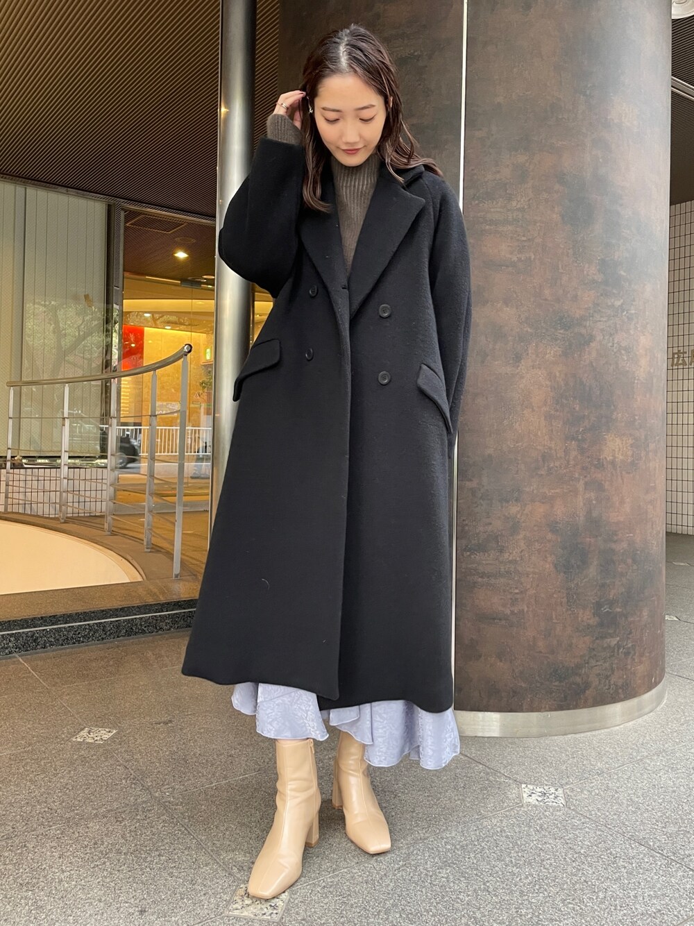 ベージュ系のニット/セーター、ベージュ系のブーツ、ブラック系のその他アウターを着用したレディースの冬コーディネートの1枚目の写真