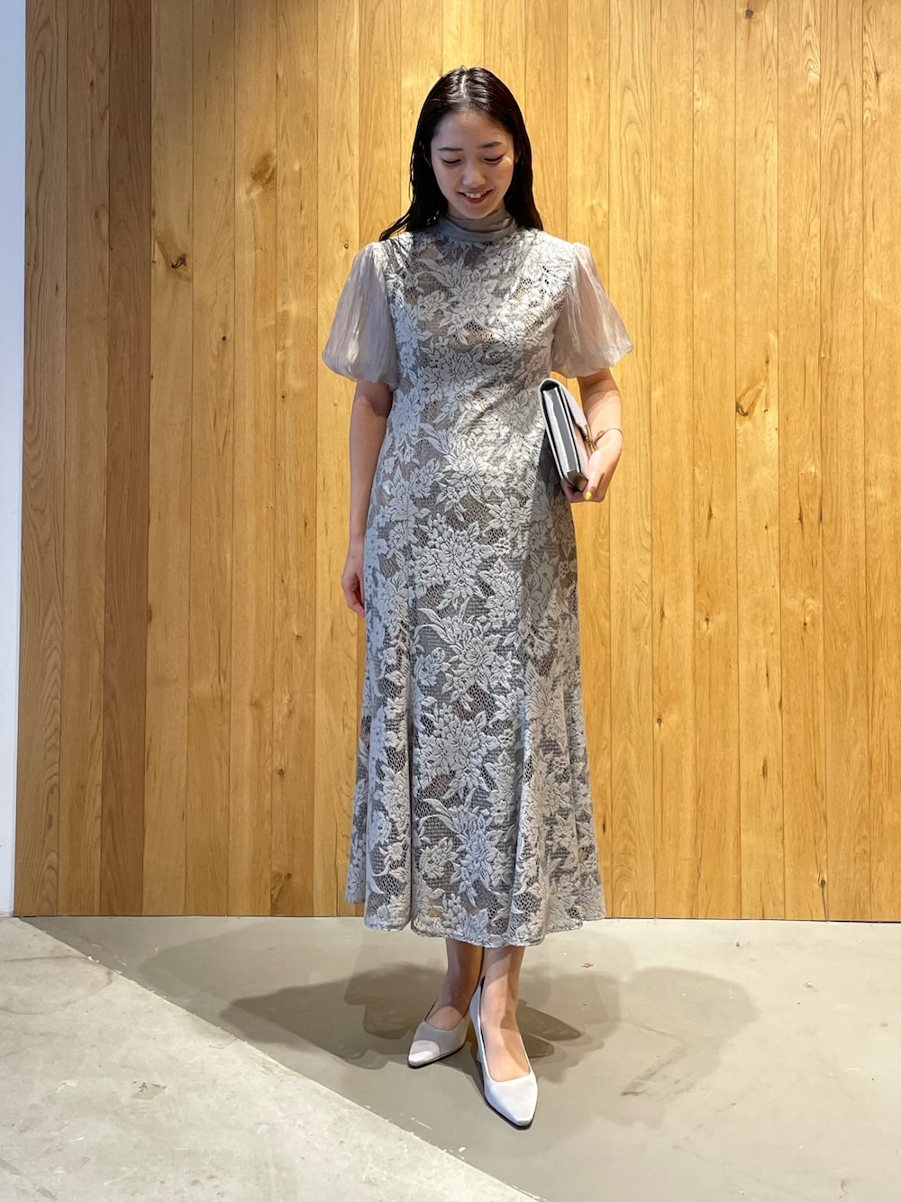 グレー系のパンプス、グレー系のクラッチバッグ、グレー系のドレスを着用したレディースの冬コーディネートの1枚目の写真