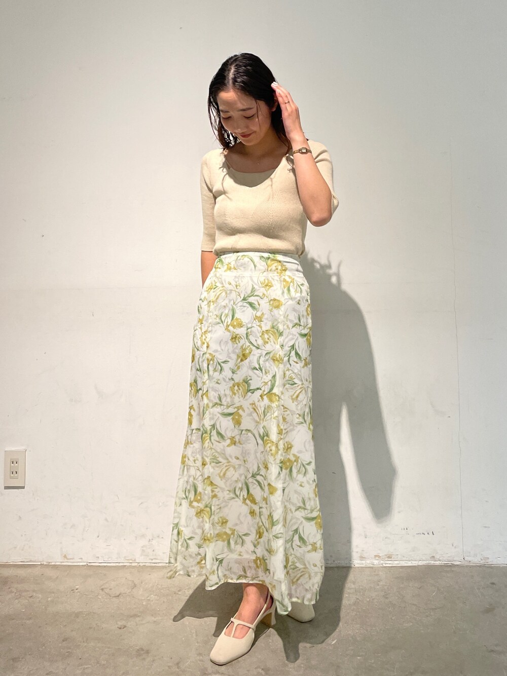 ホワイト系のパンプス、ホワイト系のスカート、ホワイト系のニット/セーターを着用したレディースの冬コーディネートの1枚目の写真