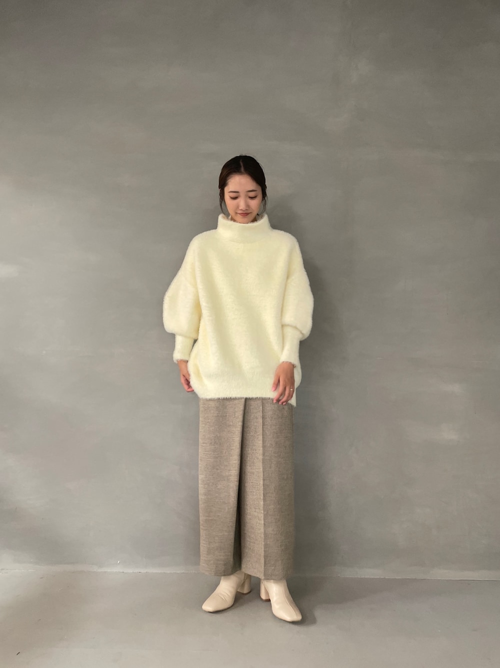 ホワイト系のニット/セーター、ベージュ系のその他パンツ、ホワイト系のブーツを着用したレディースの夏コーディネートの1枚目の写真