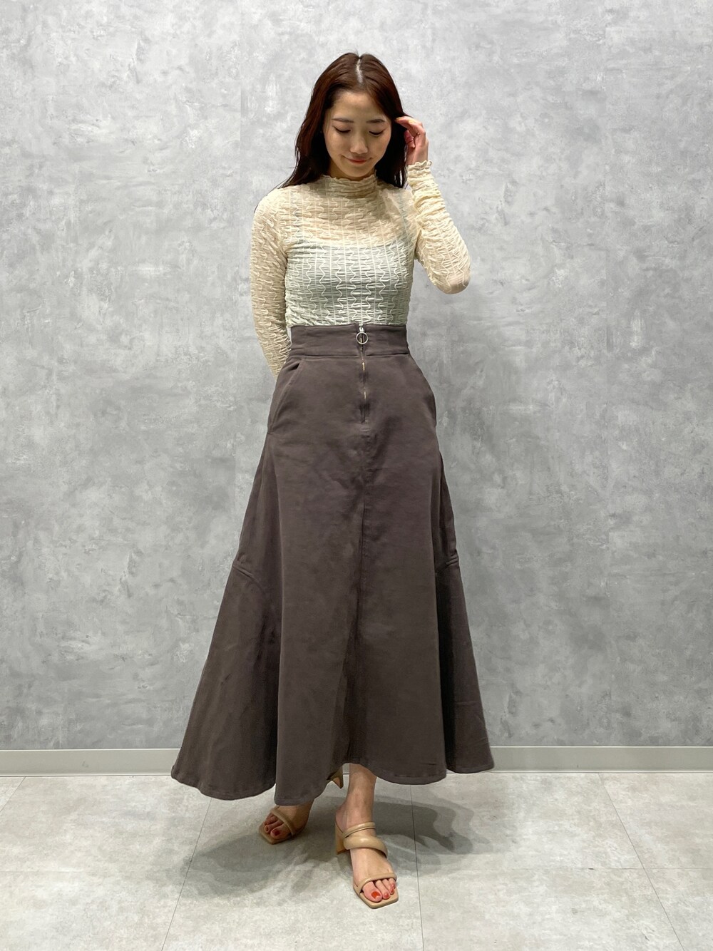 ベージュ系のサンダル、グレー系のスカート、ホワイト系のTシャツ/カットソーを着用したレディースの春コーディネートの1枚目の写真